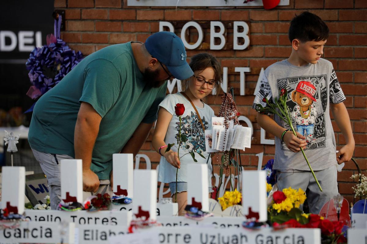 Un hombre y sus dos hijos presentan sus respetos en el memorial de la escuela primaria Robb, donde un hombre armado mató a 19 niños y dos adultos, en Uvalde, Texas, EE. UU., el 28 de mayo de 2022. REUTERS/Marco Bello