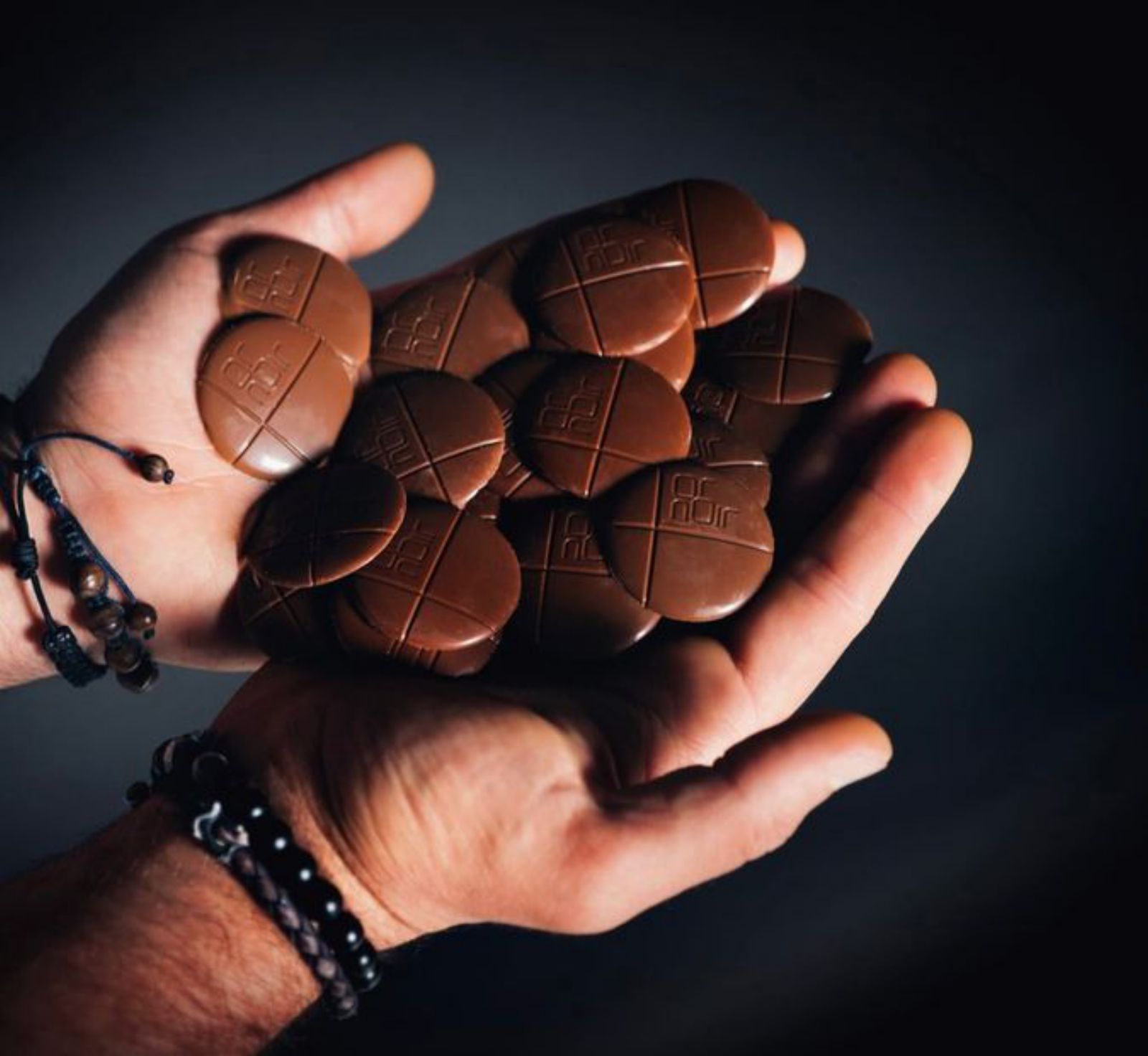 Pastillas de chocolate en las manos del pastelero asturiano.