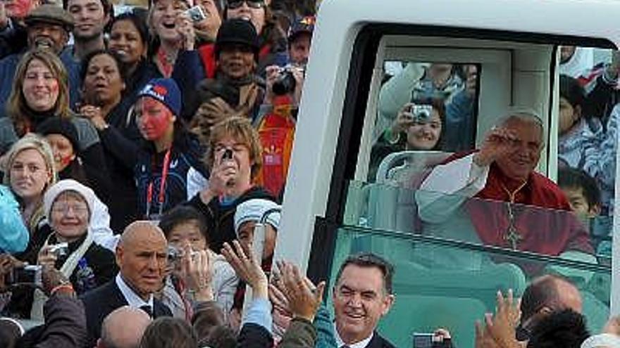 El papa Benedicto XVI (dha), saluda a los fieles a su llegada en el famoso &quot;papamóvil&quot; a la misa oficiada al aire libre con motivo de la celebración del 23  Día Mundial de la Juventud en Sídney (Australia). Cientos de miles de jóvenes peregrinos asistieron al acto en el que el Pontífice se despidió de los jóvenes católicos en la ciudad australiana y los ha citado para dentro de tres años en Madrid, lugar que ha escogido como sede de la próxima Jornada Mundial de la Juventud.