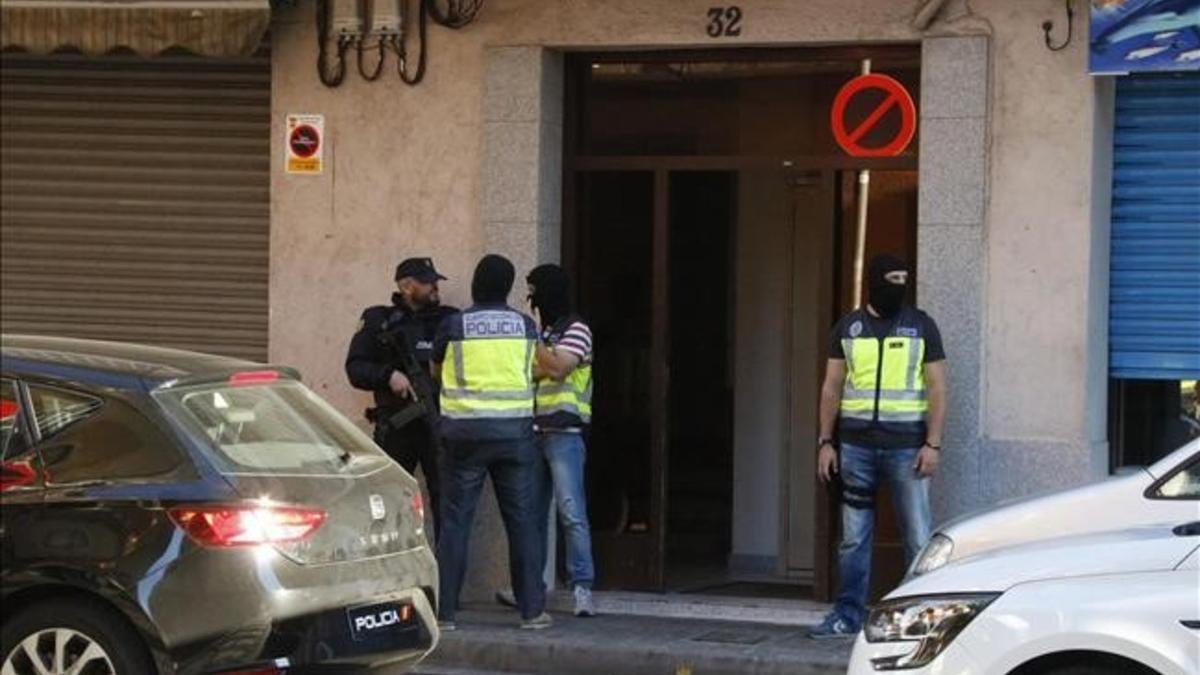 Agentes de la Policía Nacional montan guardia en la puerta del domicilio de uno de los presuntos yihadistas detenidos este miércoles en Canovelles (Barcelona)