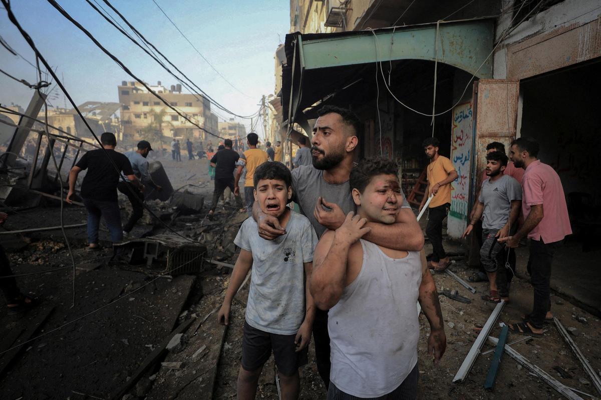 Els palestins busquen víctimes entre les restes d'una edificació atacada per Israel a Gaza.