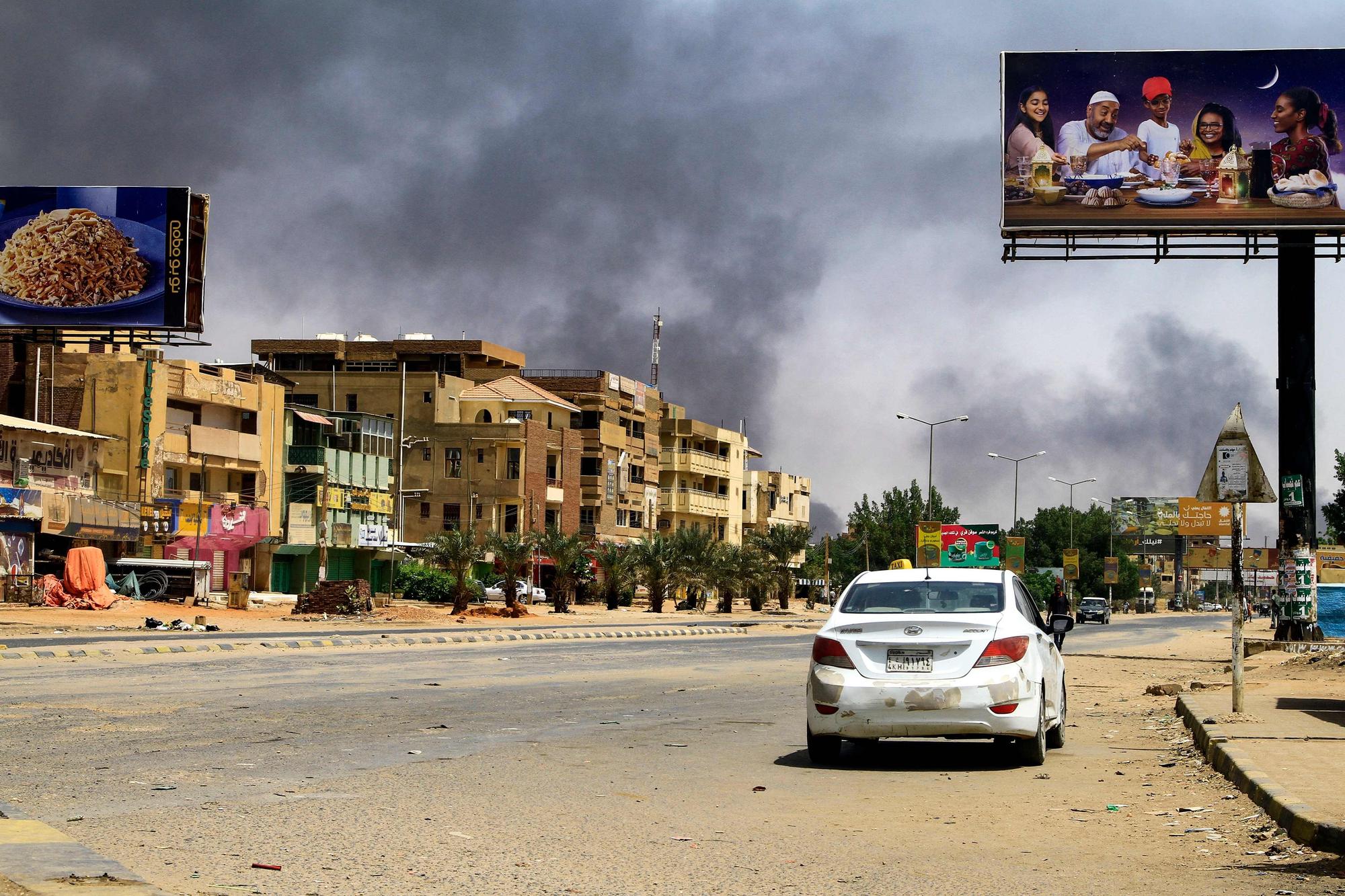 Humo de los bombardeos en una calle de Jartum casi desierta, este sábado.