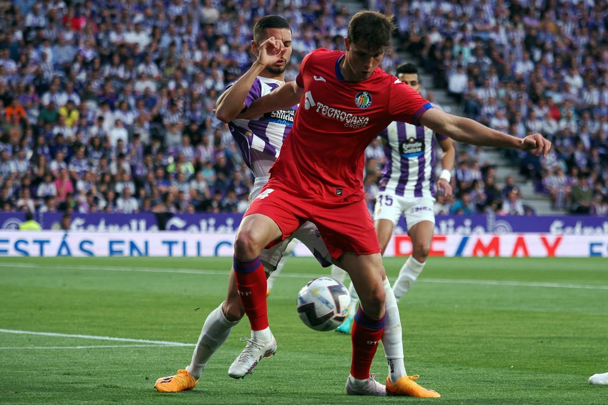 VALLADOLID, 04/06/2023.- El delantero del Getafe Juan Miguel Latasa (d) lucha con Javi Sánchez, del Valladolid, durante el partido de la última jornada de Liga que Real Valladolid y Getafe CF disputan hoy domingo en el estadio Josá Zorrilla, en Valladolid. EFE/R. García