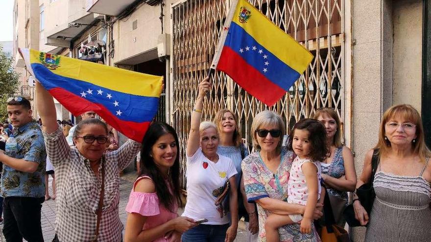 Un grupo de venezolanas con banderas de su país, antes de votar en el local de Vigo. // Marta G. Brea