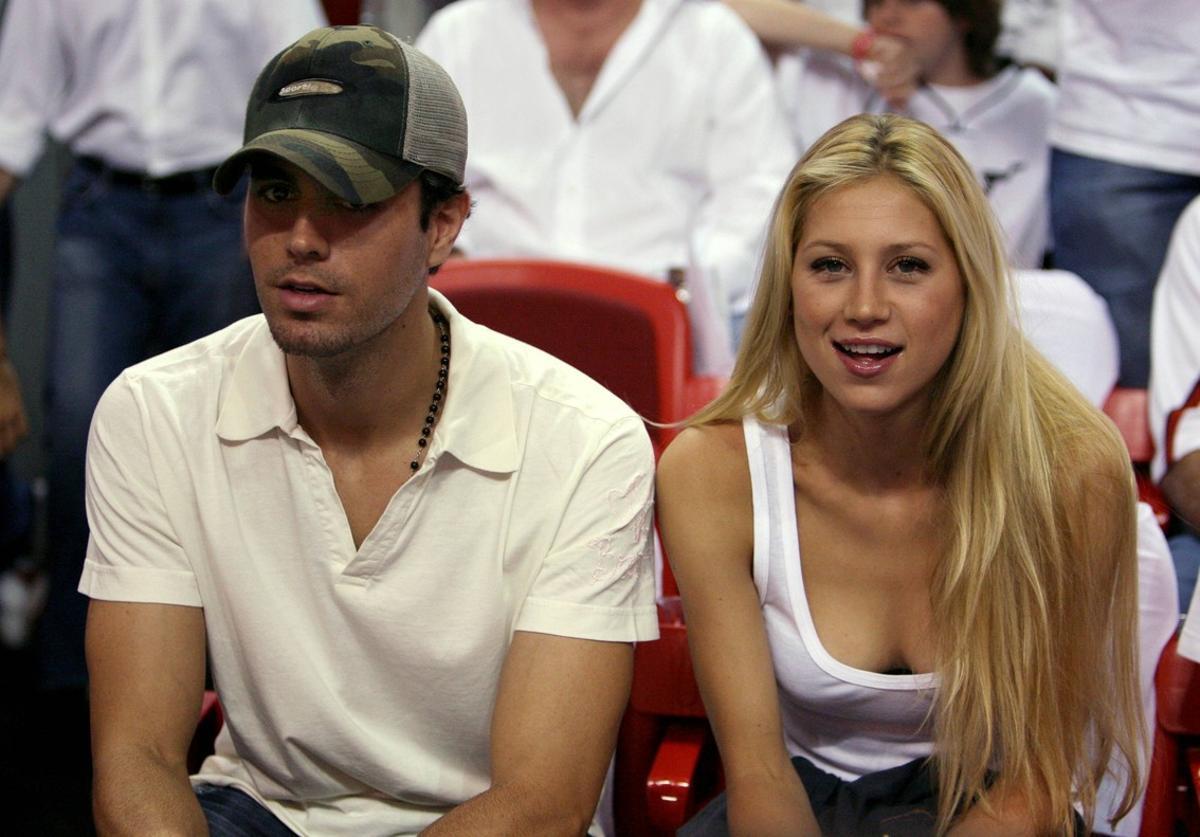 Singer Enrique Iglesias (L) and tennis star Anna Kournikova of Russia watch as the Dallas Mavericks meets the Miami Heat during Game 3 of their NBA Finals basketball game in Miami June 13, 2006.   REUTERS/Lucy Nicholson     (UNITED STATES)