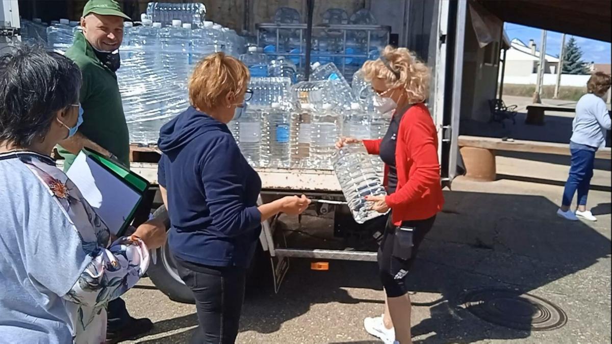 La diputada Atilana Martínez acudió ayer a Bercianos a interesarse por la situación de los vecinos y hacer el reparto del agua potable. / E. P.