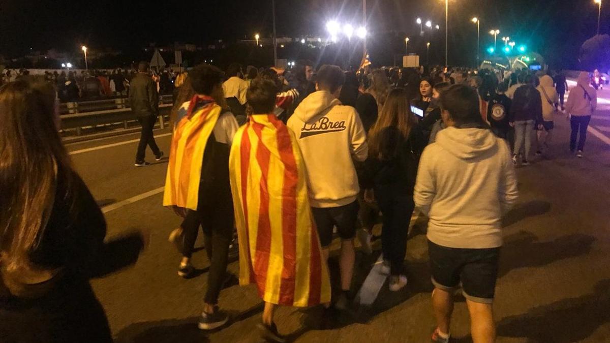 Dos chavales, uno con una estelada y otro con una 'senyera', cortan una carretera en Mataró.