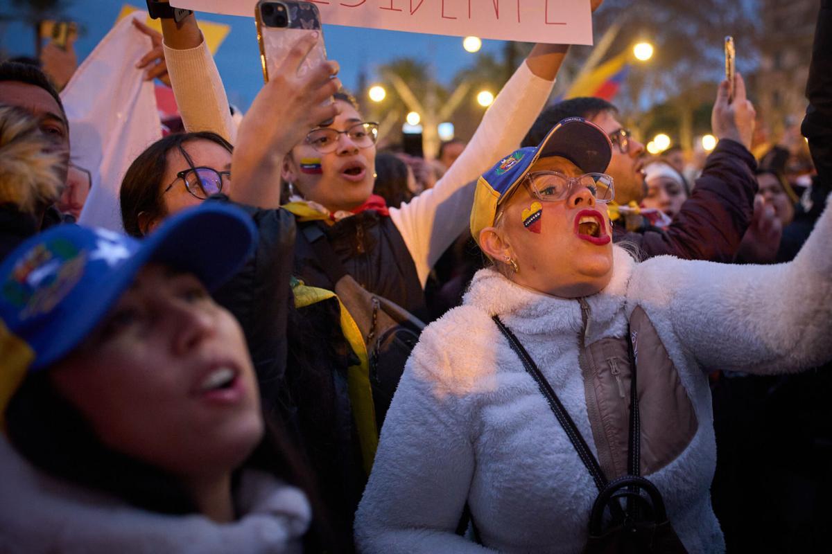 La gente grita consignas contra el presidente venezolano Nicolás Maduro mientras se reúnen en el centro de Barcelona, España, el domingo, enero. 4, 2026. (AP Foto/Emilio Morenatti)