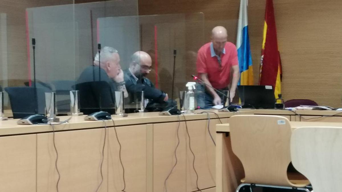 Uno de los acusados, primero por la izquierda, junto a su abogado durante el juicio en su contra.