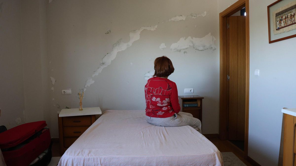 B. M., en la habitación principal de su vivienda en Navia, en donde se pueden comprobar los daños por la humedad.