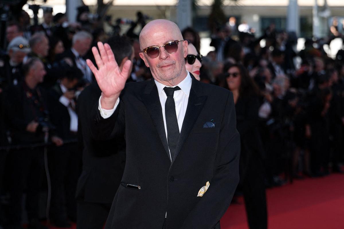 El director francés Jacques Audiard saluda al llegar a la ceremonia de inauguración y a la proyección de la película "El beso eléctrico" en la 79.ª edición del Festival de Cine de Cannes