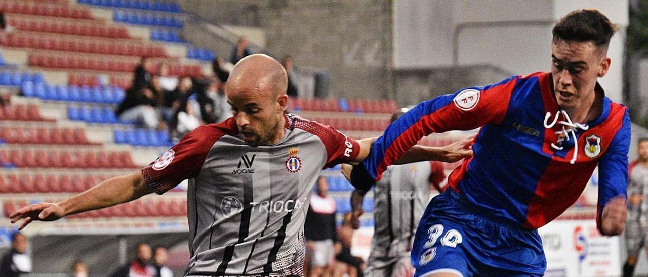 Sergio García, con el balón, ante Álex Mariscal, del Langreo. | RAI