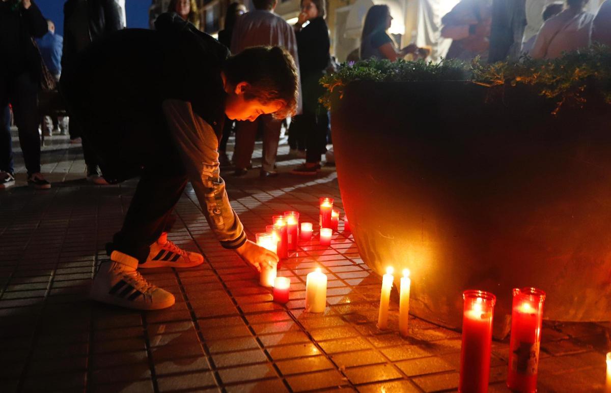 Un niño coloca su vela en memoria de las víctimas mortales de la dana en Paiporta.