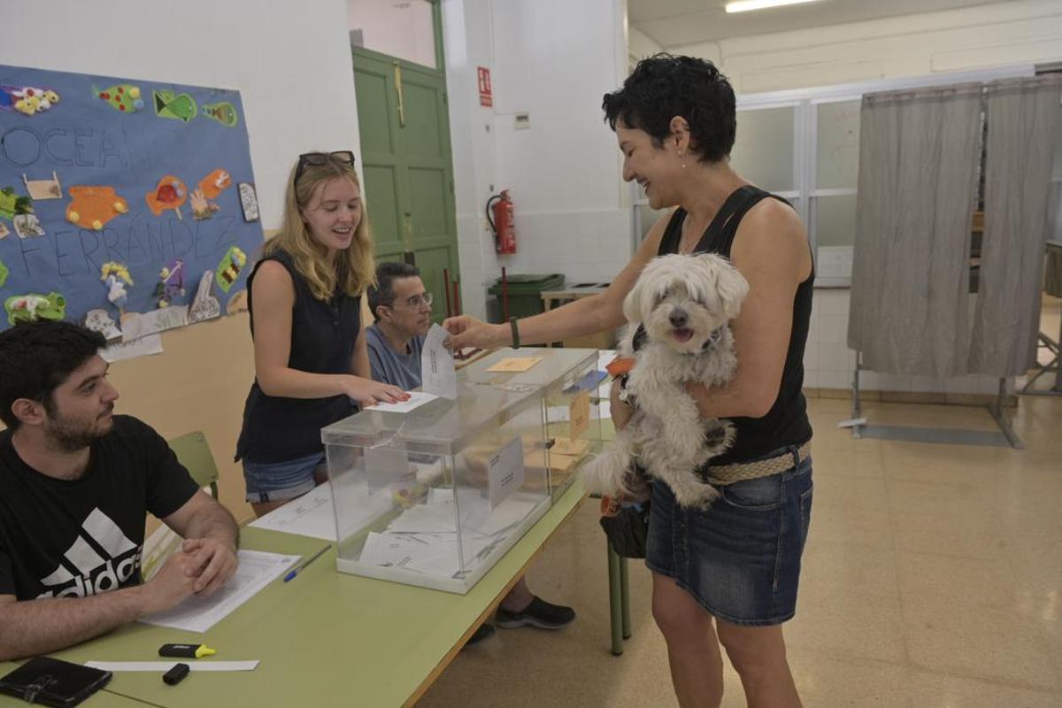 Una vecina acude con su mascota a votar a un colegio de Elche