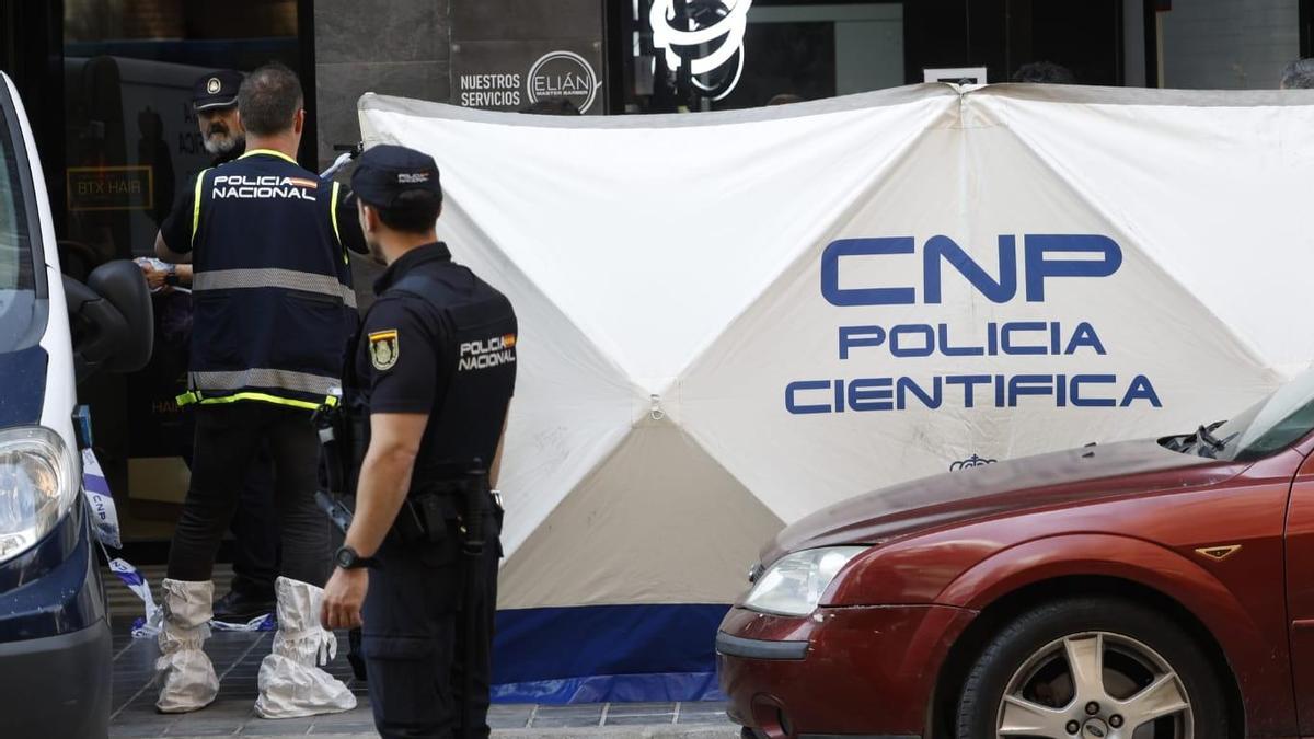 La Policía Nacional colocó un parabán para evitar las miradas de los curiosos y proteger el cuerpo del peluquero muerto de una cuchillada a manos de su compañero de trabajo.
