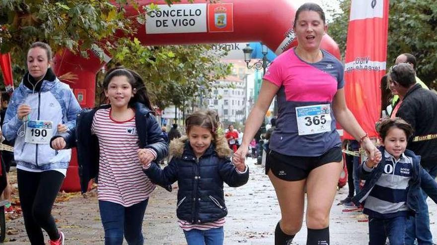 Una atleta, de la mano de tres niños, en la Alameda Suárez Llanos.