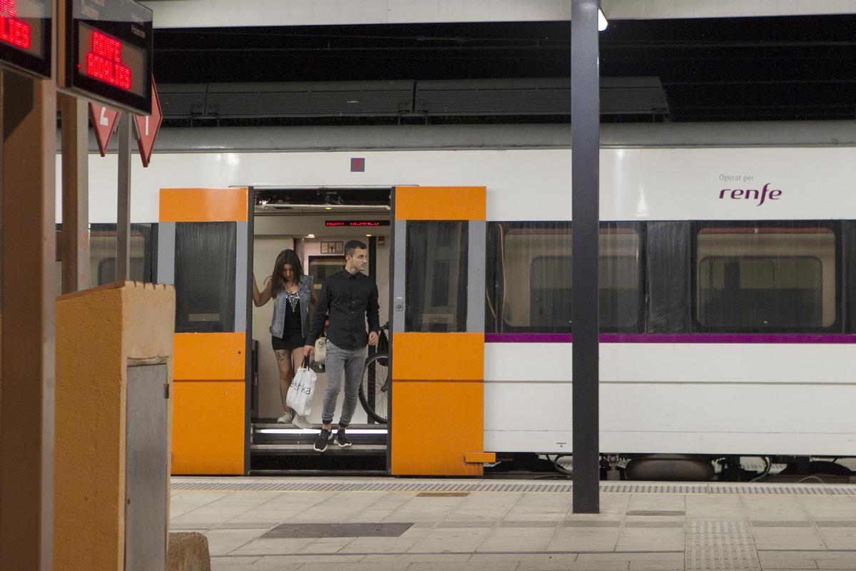 Unos viajeros descienden del tren en la estación de Rodalies de Blanes (Selva).