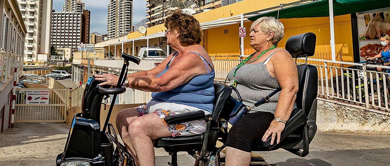 Turistas pasan frente a un edificio de viviendas en la zona inglesa de Benidorm. | DAVID REVENGA