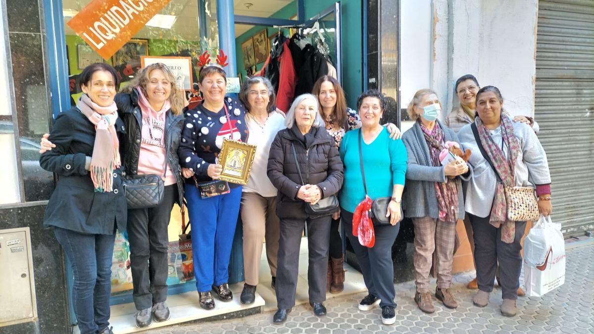 Las voluntarias del rastrillo solidario del Cerro del Águila con un cuadro de la Virgen del Rocío, regalo de la hermandad por su ayuda en la obra social.