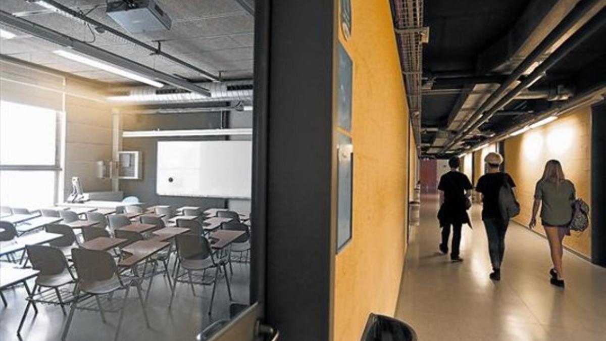 Tres estudiantes recorren un pasillo vacío en la facultad de Geografía e Historia de la Universitat de Barcelona, donde aún hay plazas vacantes, el pasado viernes.