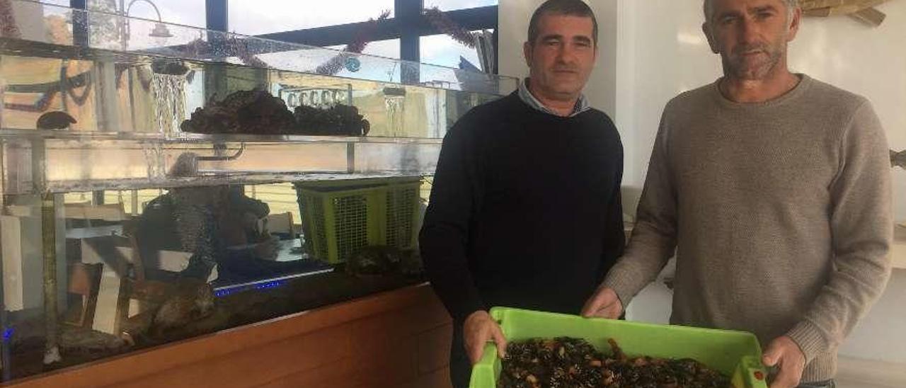 Francisco Castro, a la izquierda, recibe percebes del pescador Emilio Gutiérrez, ayer, en Candás.