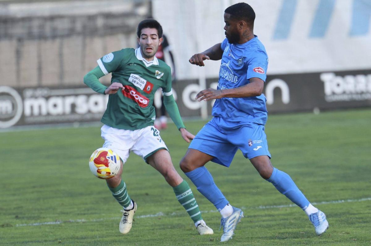 Guille Pinin lucha con un rival por hacerse con el balón durante un partido en O Vao. | JOSÉ LORES