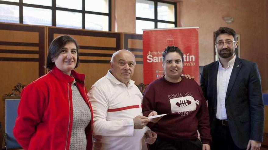 Marina Vallina entrega el dinero recaudado en el evento solidario a Manuel Pérez León, flanqueados por Enrique Fernández y Sandra García.