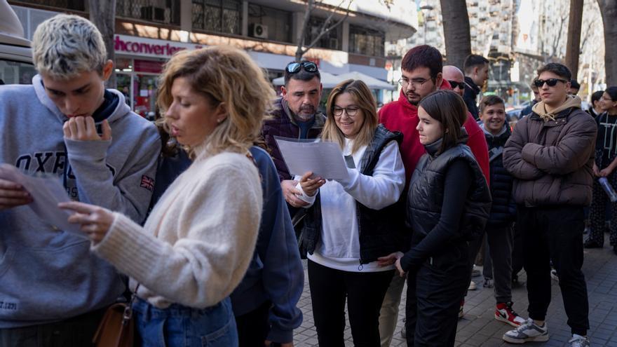 Los clientes aprovechan la cola para mirar el menú.