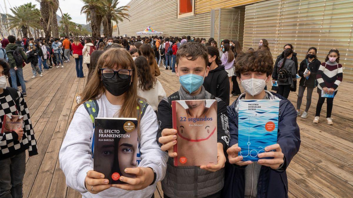 Tres adolescentes sostienen las obras finalistas.