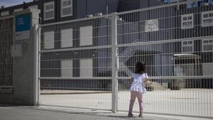 Una niña, frente a la escuela cerrada Flor de Maig, en el Poblenou de Barcelona.