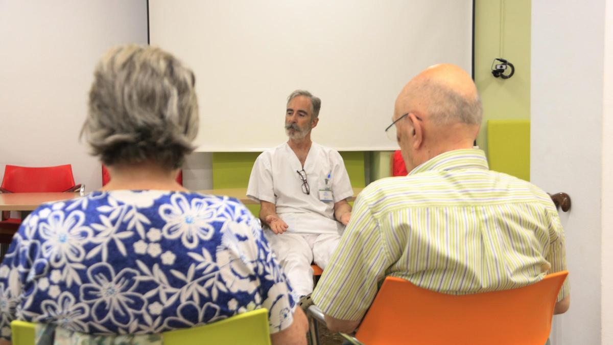 Dos usuaris del centre de dia de l'Associació de Familiars d'Alzheimer (AFA) de Barcelona seguint les indicacions de l'instructor en un taller de psicomotricitat
