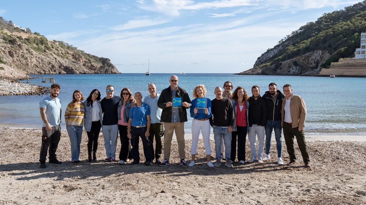 Parte del equipo de los hoteles Hyde y Mondrian Ibiza celebran la certificación en la playa de Cala Llonga.