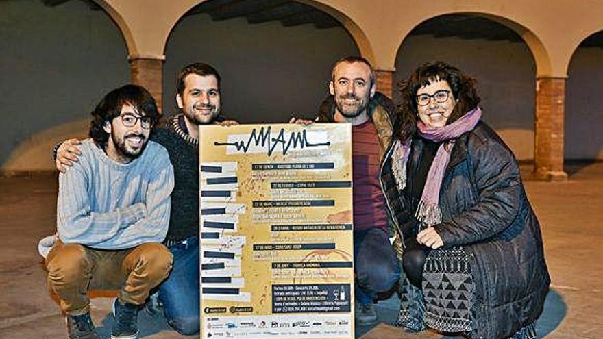 Els organitzadors del MAM amb el cartell amb la programació, ahir a la plaça del Puigmercadal