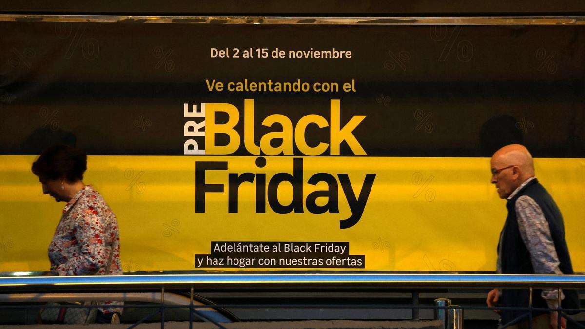 Dos personas pasan ante un anuncio de ofertas del Black Friday en Barakaldo.