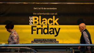 Dos personas pasan ante un anuncio de ofertas del Black Friday en Barakaldo.