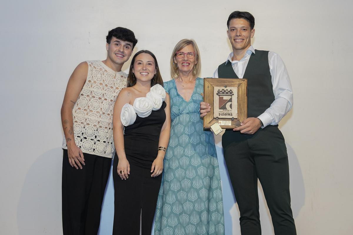 Los hijos de Manoli Guzman con el trofeo a la mejor cabo cristiana del 2024, acompañados por la presidenta de Intercomparsas