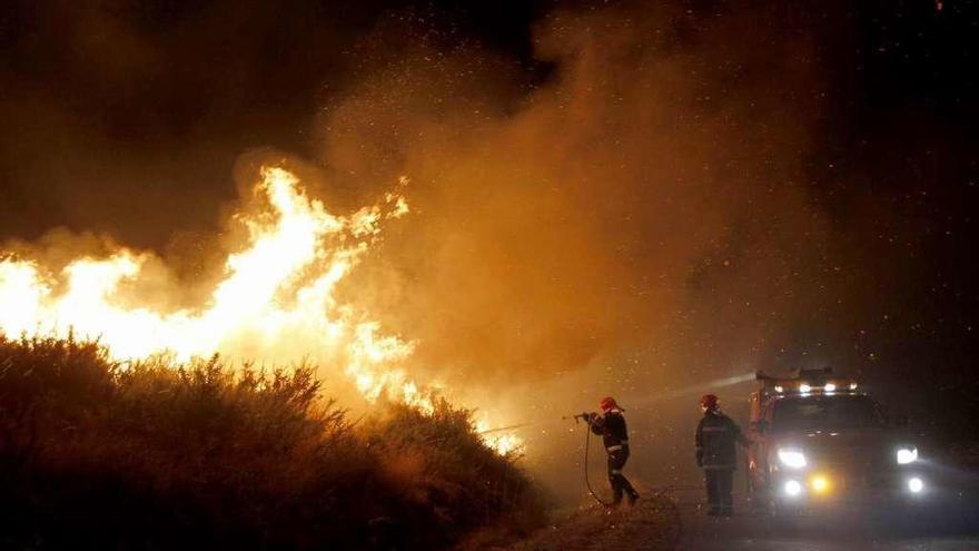 Dos brigadistas, apagando el incendio de Fornelos.