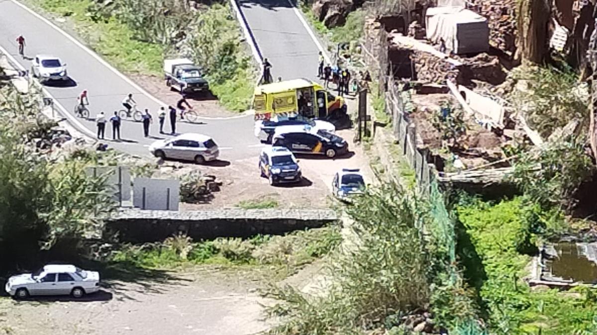 Efectivos de la Policía Nacional y sanitarios del SUC en la carretera de Ayagaures junto al ciclista fallecido.