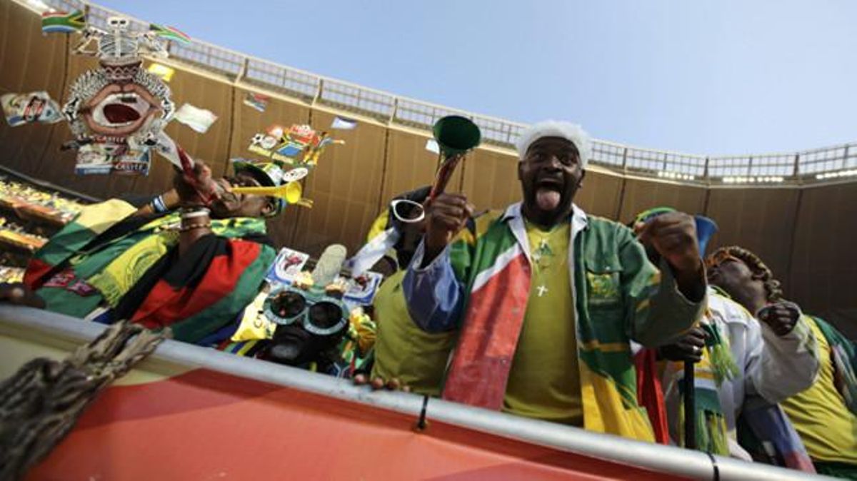 Uns aficionats sud-africans s’animen amb vuvuzuelas, cornetes de plàstic que emetran durant un mes el soroll oficial d’aquest Mundial 2010.