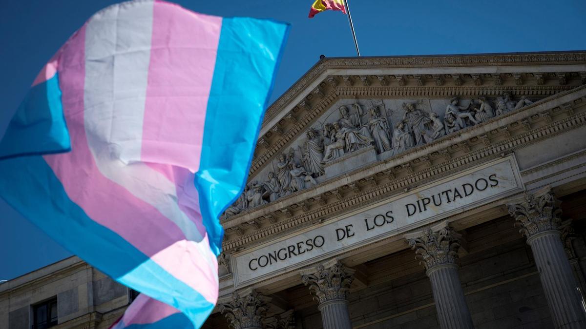 Una bandera trans ondea frente al Congreso de los Diputados.