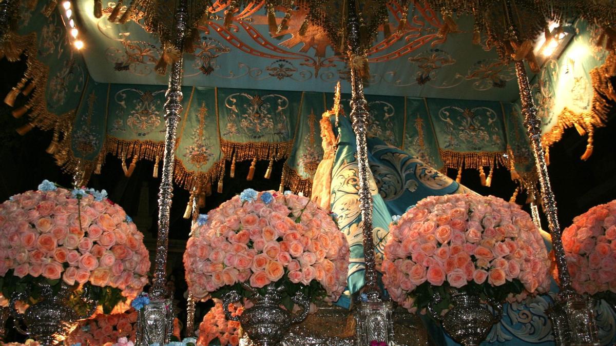 El trono iba decorado con rosas en un suave color salmón sobre el que se podían contemplar claveles azules que le lanzaban a su paso desde los palcos.