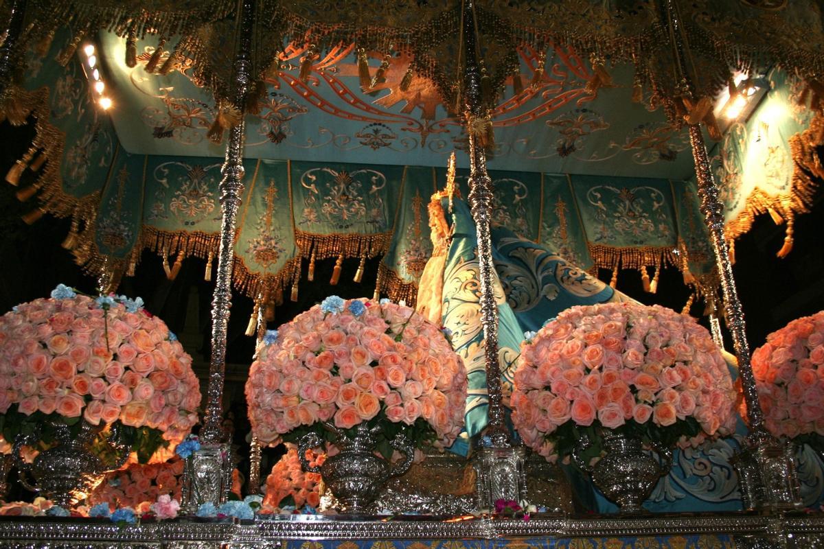 El trono iba decorado con rosas en un suave color salmón sobre el que se podían contemplar claveles azules que le lanzaban a su paso desde los palcos.