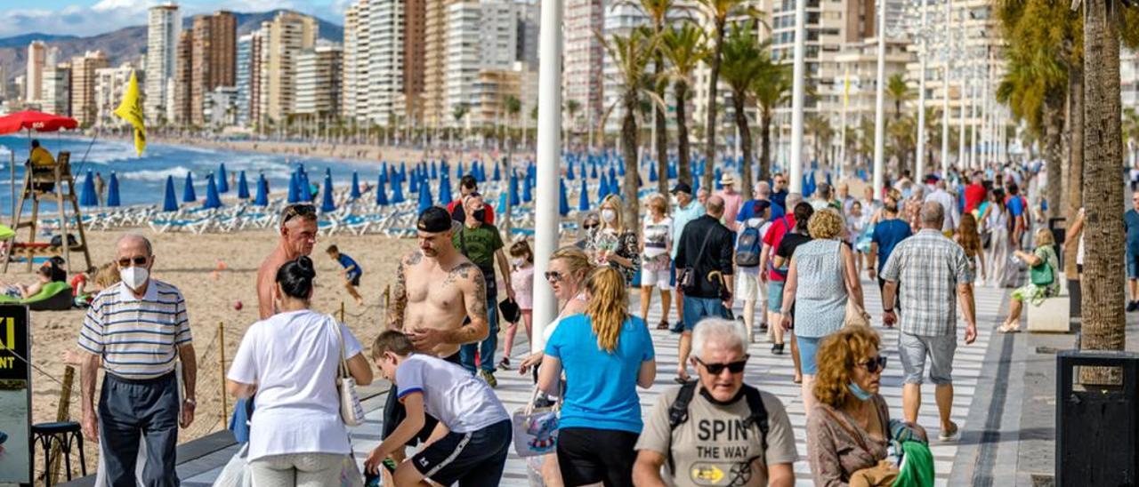 Turistas paseando por el paseo de la playa de Levante de Benidorm en octubre de 2021