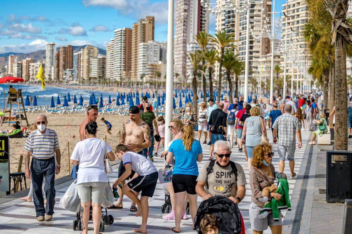Turistas paseando por el paseo de la playa de Levante de Benidorm en octubre de 2021