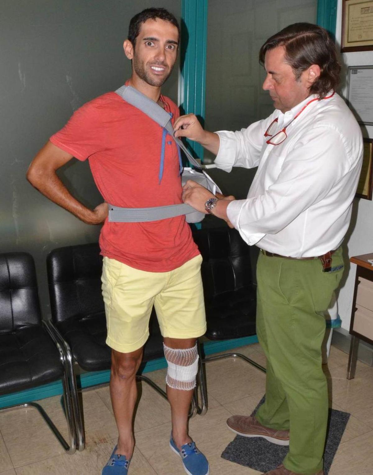 Junquera le ajusta el cabestrillo del brazo a Dani Navarro.