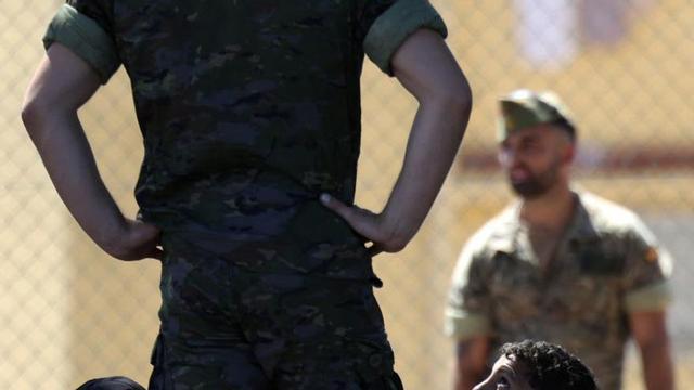 Soldats espanyols al costat d’un grup de menors marroquins. | HENRY NICHOLLS / AFP