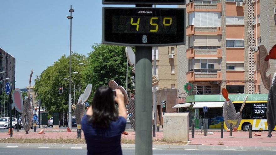 Una mujer toma una foto de un termómetro en Murcia.