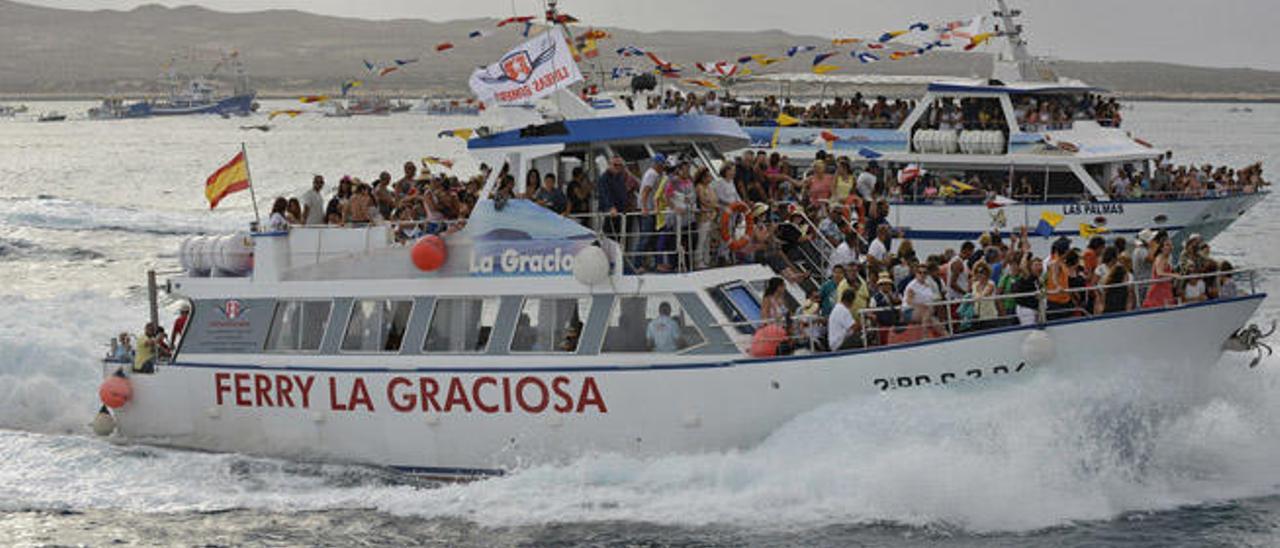 Dos de las múltiples embarcaciones que participaron ayer en la procesión marítima de la Virgen del Carmen en La Graciosa.