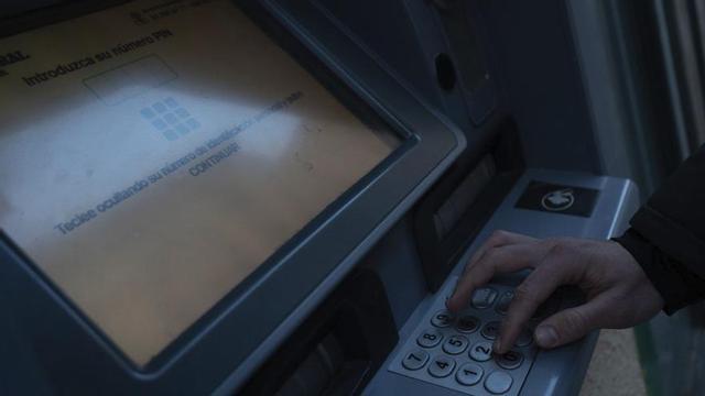 Una persona realiza una gestión en un cajero automático.