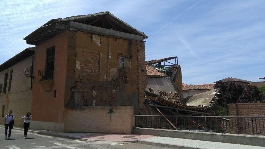 Dos jóvenes pasean junto al palacio de Bustamante, hundido en parte desde febrero.